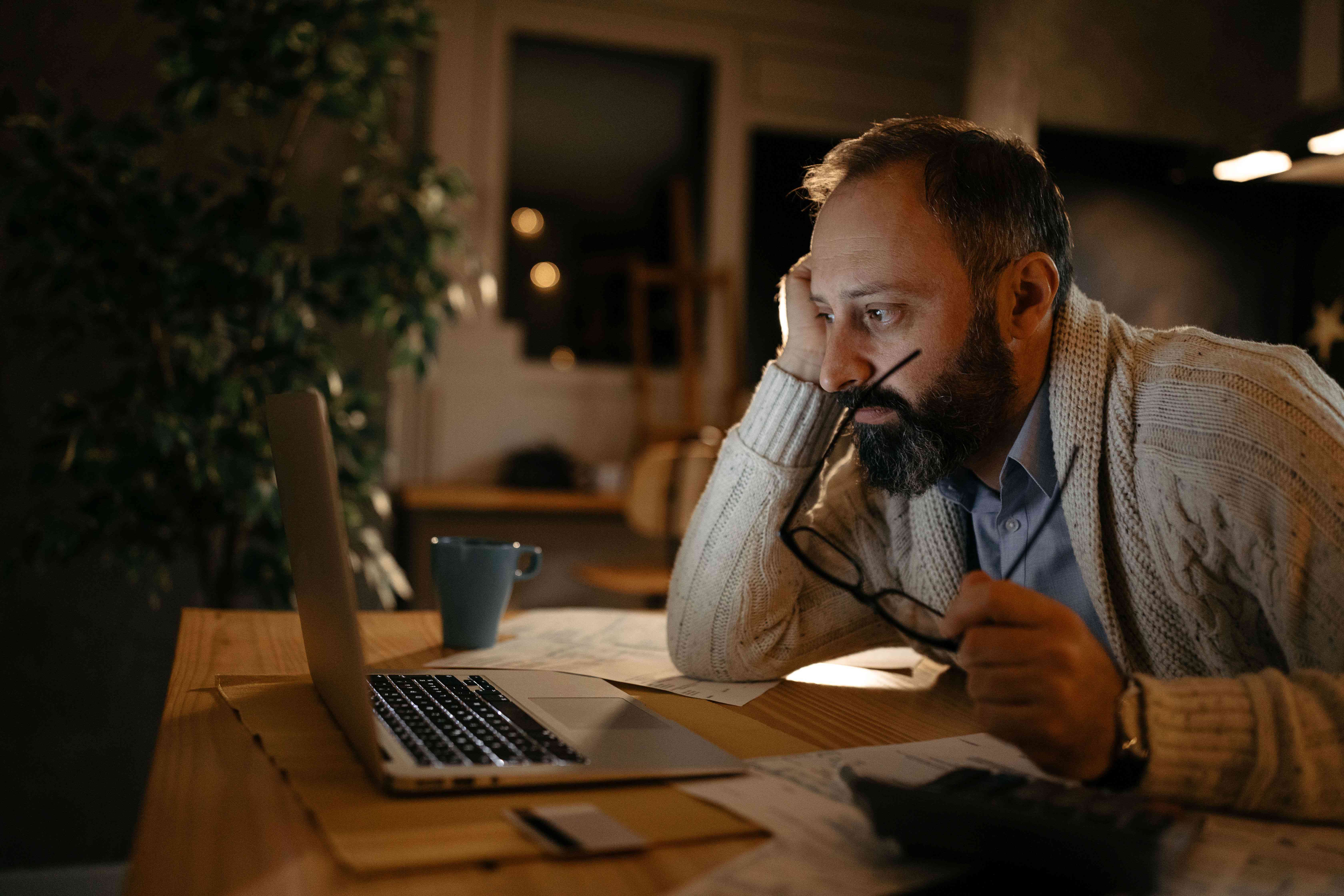 Man looking at a laptop screen in a darkened room